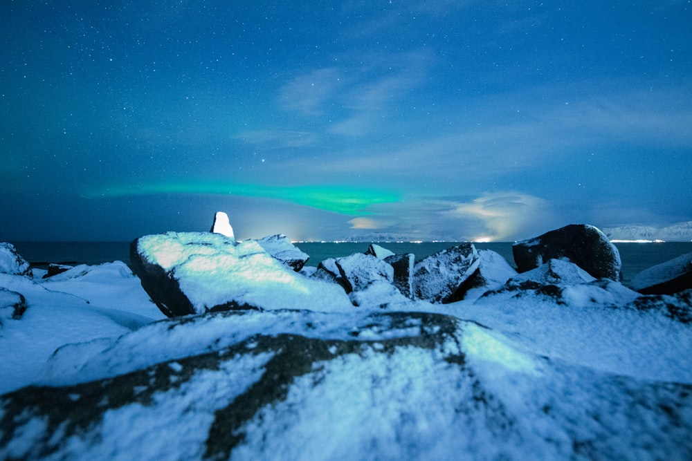 snow-covered rock formations under a calm blue sky during nighttime