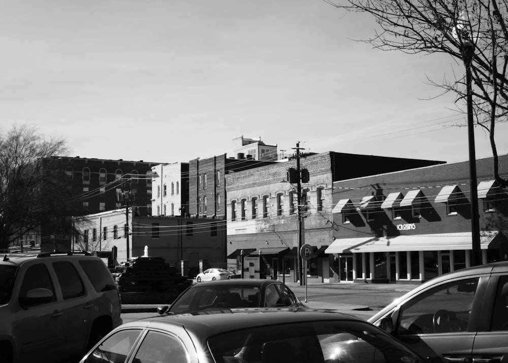 grayscale photography of buildings and vehicles during daytime