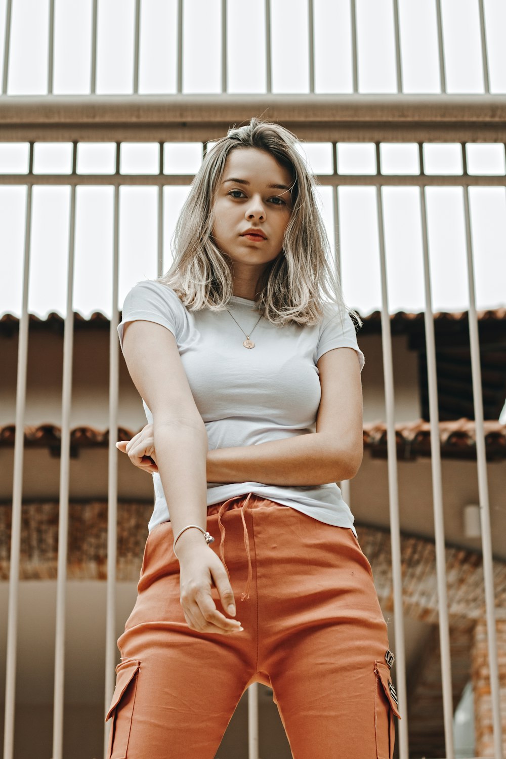 woman standing near white metal fence