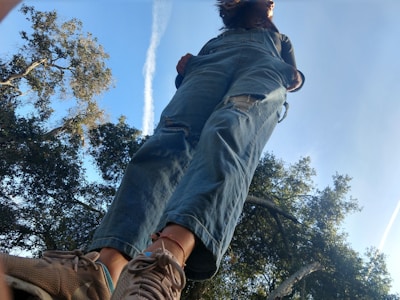 A model wearing trendy denim overalls in a city setting.