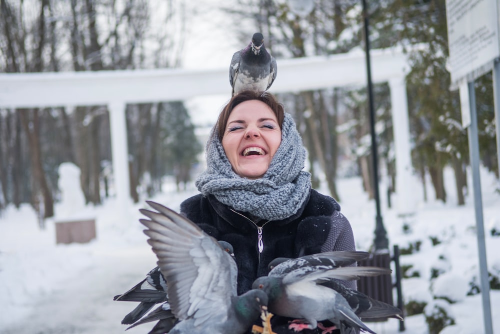 a woman with a bird on her head in the snow