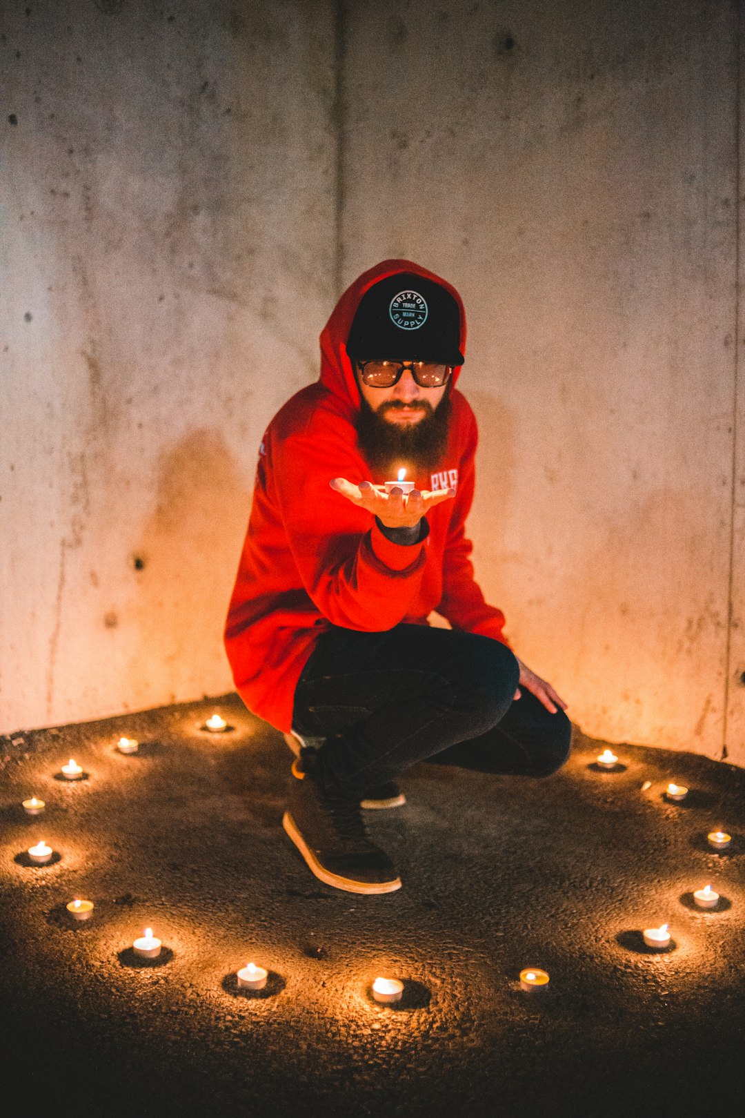 man sitting near lit candle