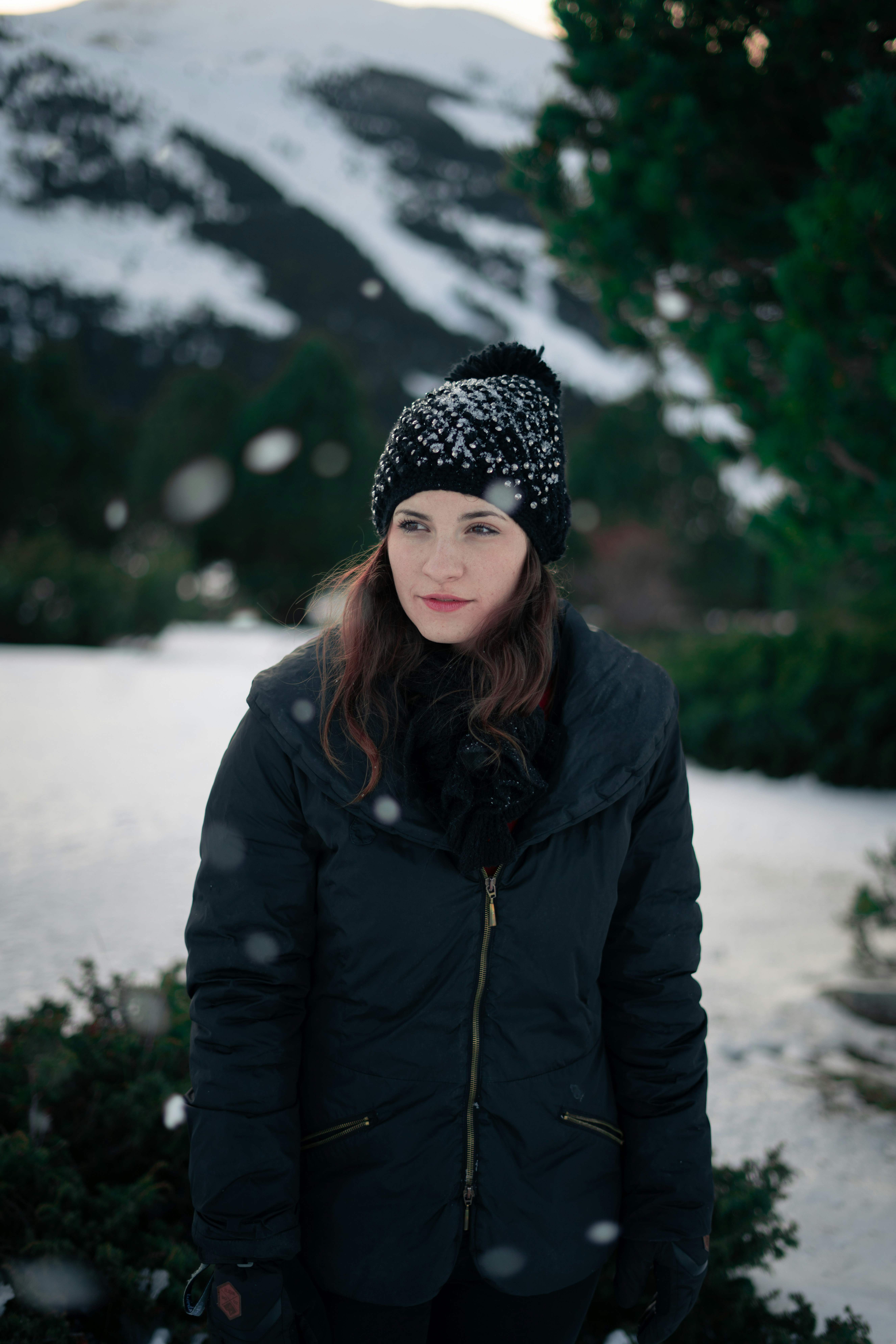 woman in black coat standing near trees during daytime