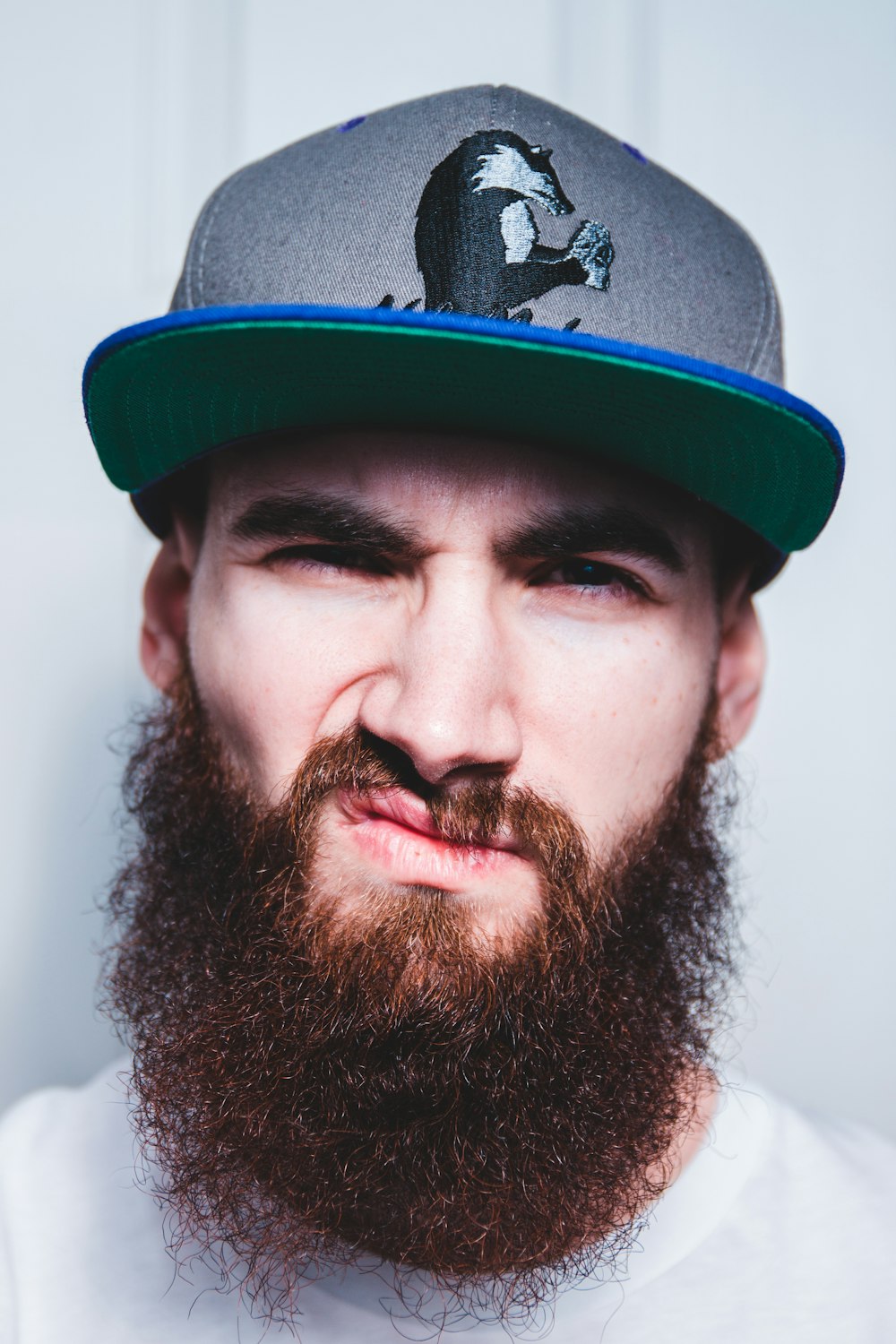 man wearing grey and green fitted cap