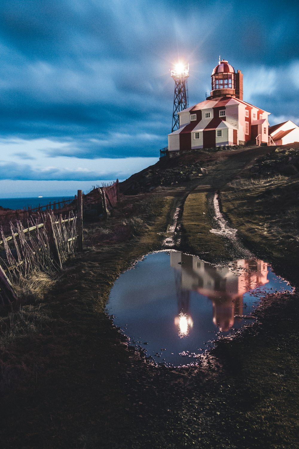 poça de água no campo de grama perto de um farol