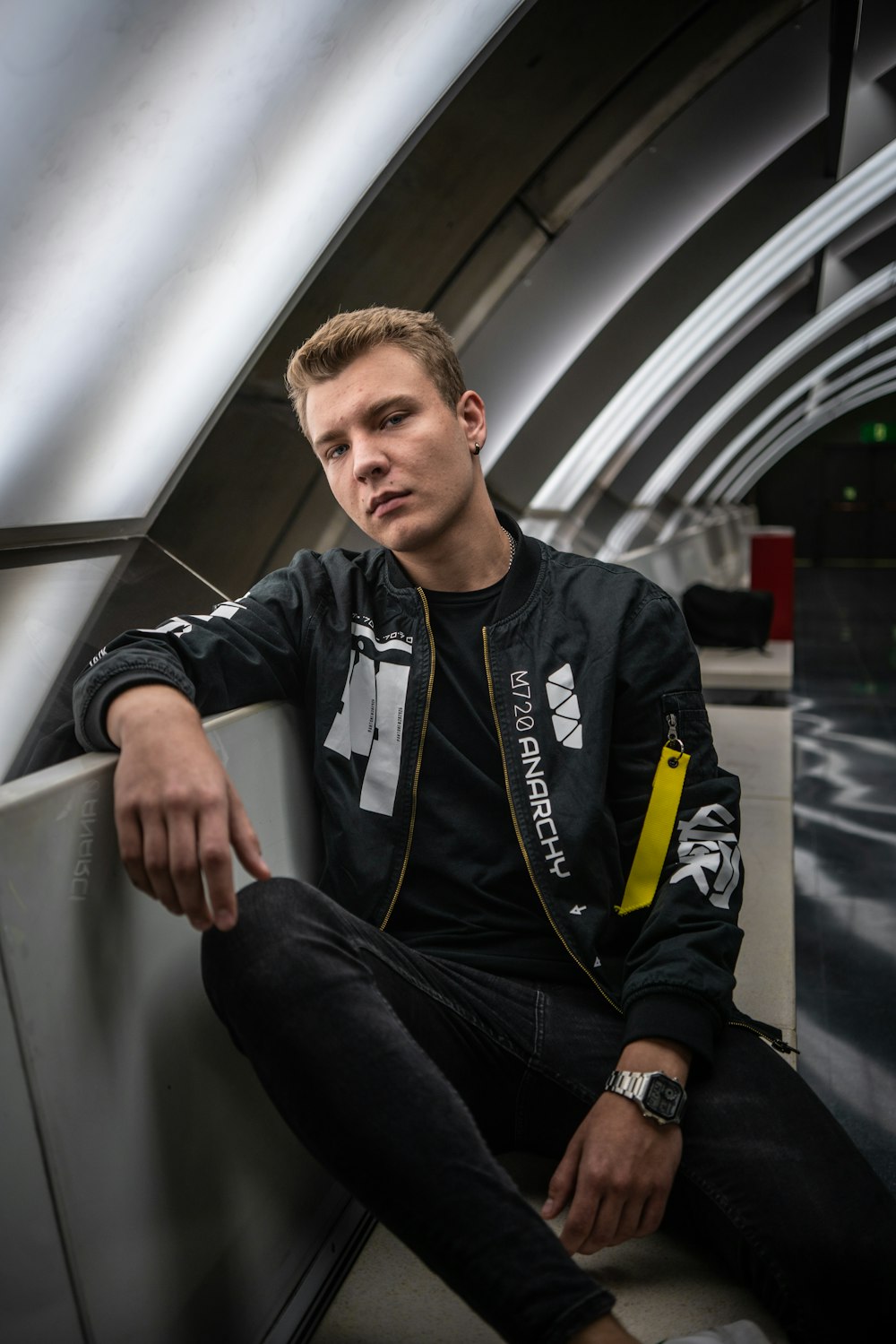 a man sitting on a bench in a subway station