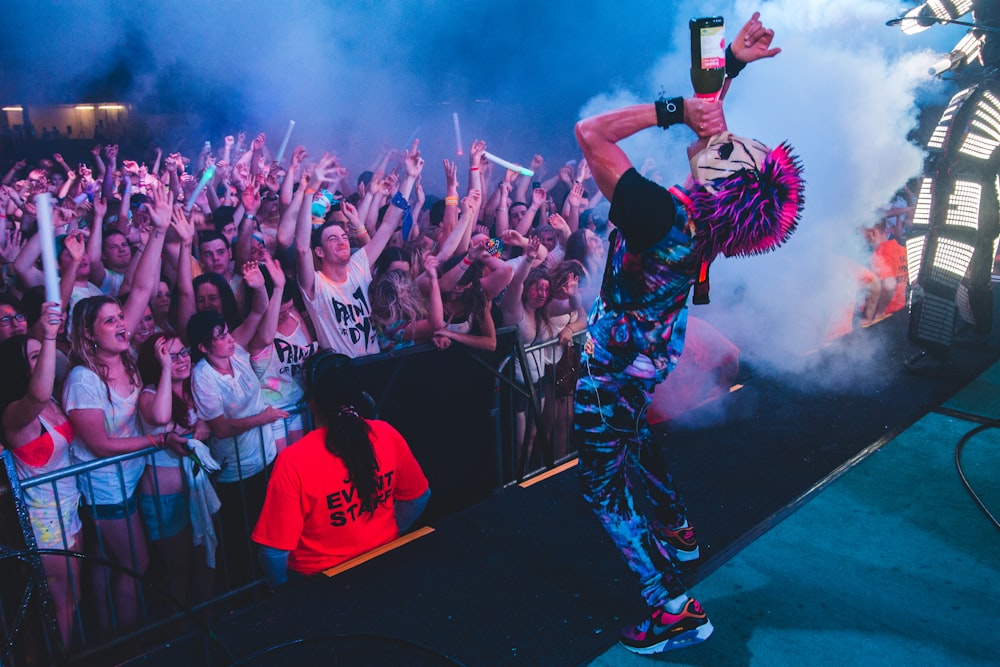 a man standing on top of a stage in front of a crowd