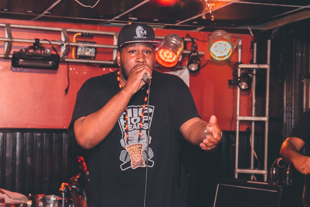 man wearing black fitted cap singing photograph