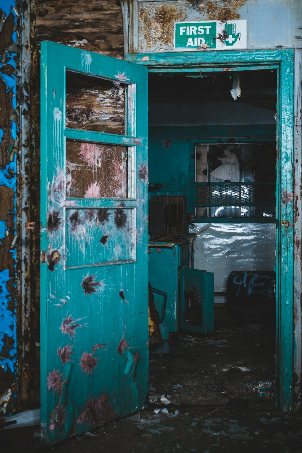 an old run down building with a green door