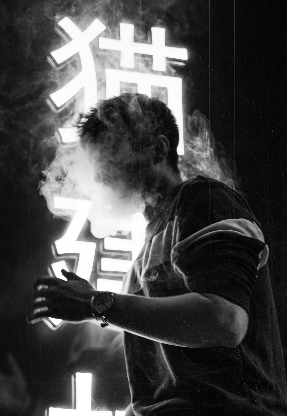 grayscale photography of man smoking cigarettes