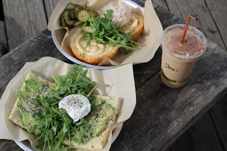A beautifully arranged wooden tray with avocado toast, a berry smoothie, and a cup of herbal tea on a rustic table.