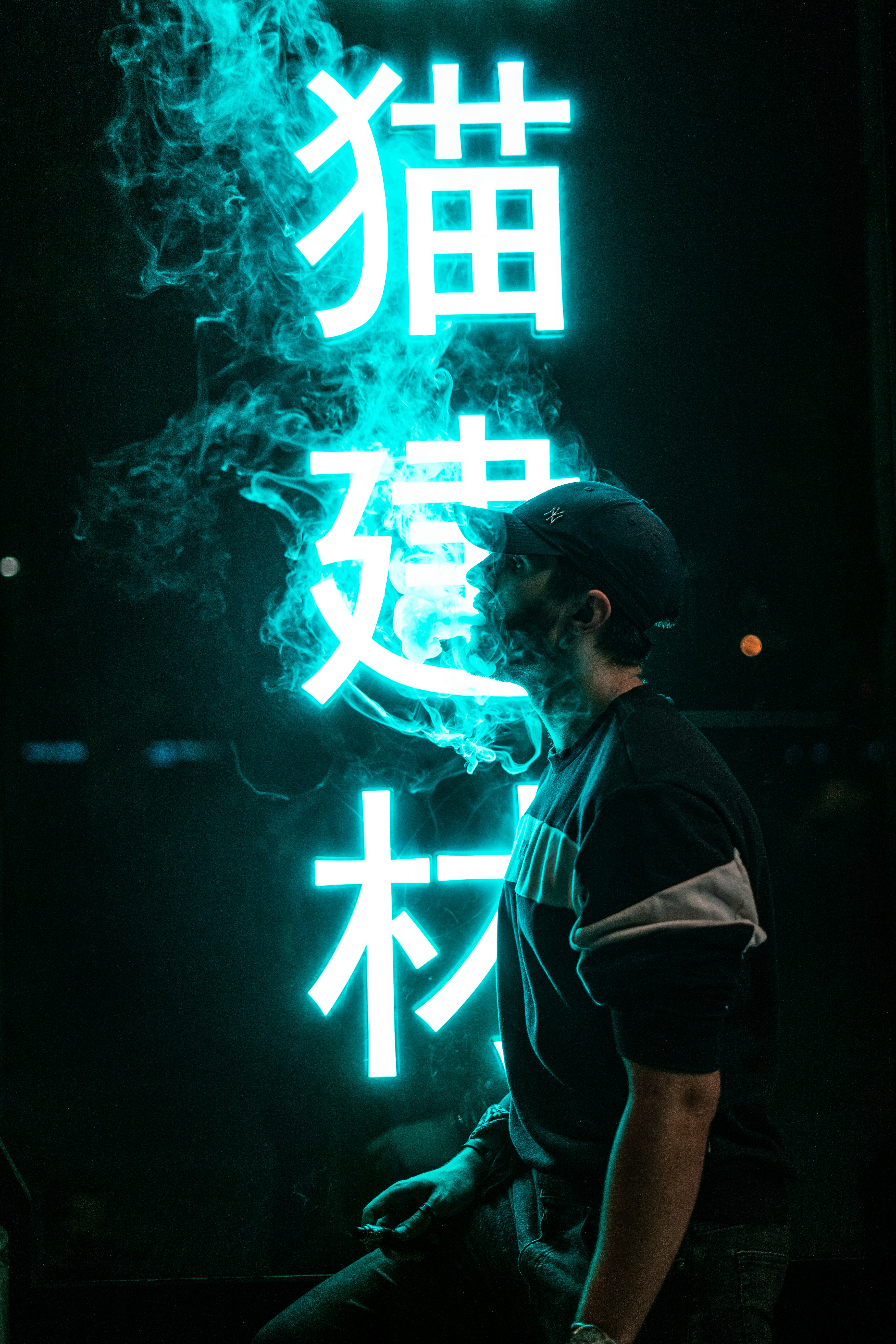 a man sitting in front of a neon sign