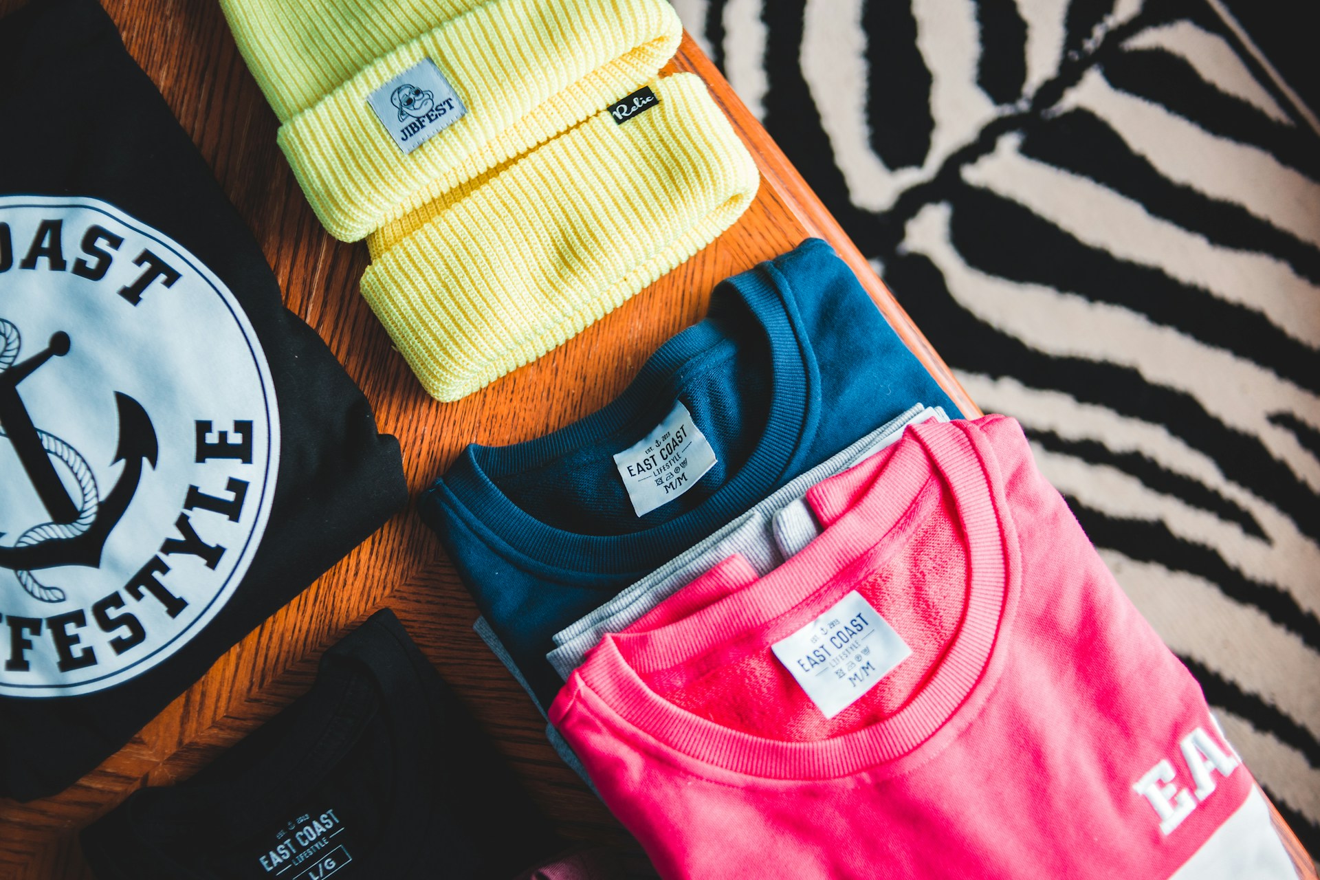 two blue and pink crew-neck shirts on orange textile