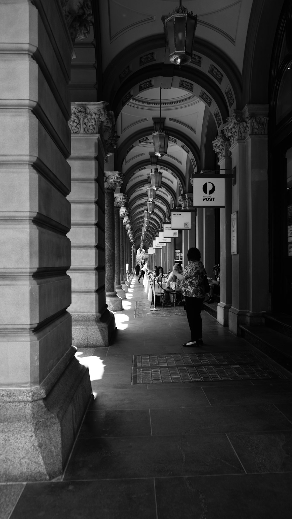 a black and white photo of a person walking down a hallway