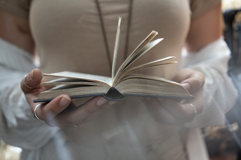 shallow focus photo of person's holding book