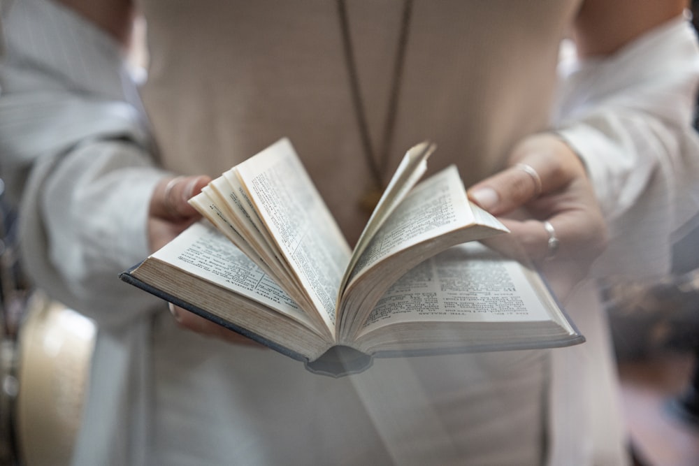 selective focus photography of person holding book
