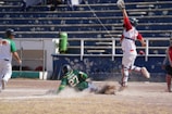 Action shot of BlueDiamond softball player sliding into home plate under bright stadium lights.