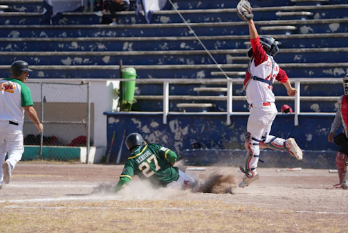 A thrilling game moment with players sliding into base under bright stadium lights.