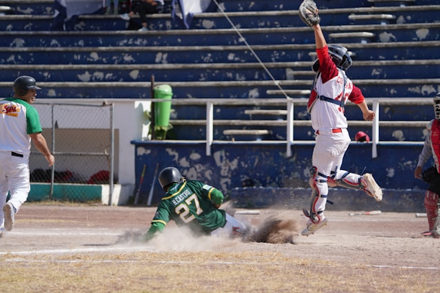 A dynamic shot of a baseball player sliding into home plate under a bright stadium light.