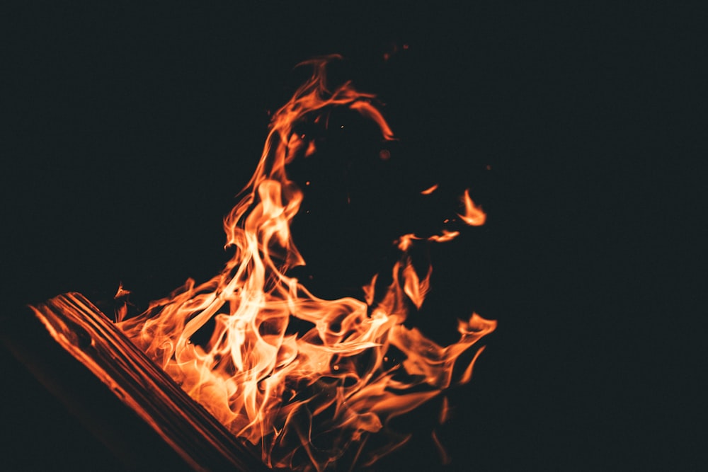 a close up of a book on fire in the dark