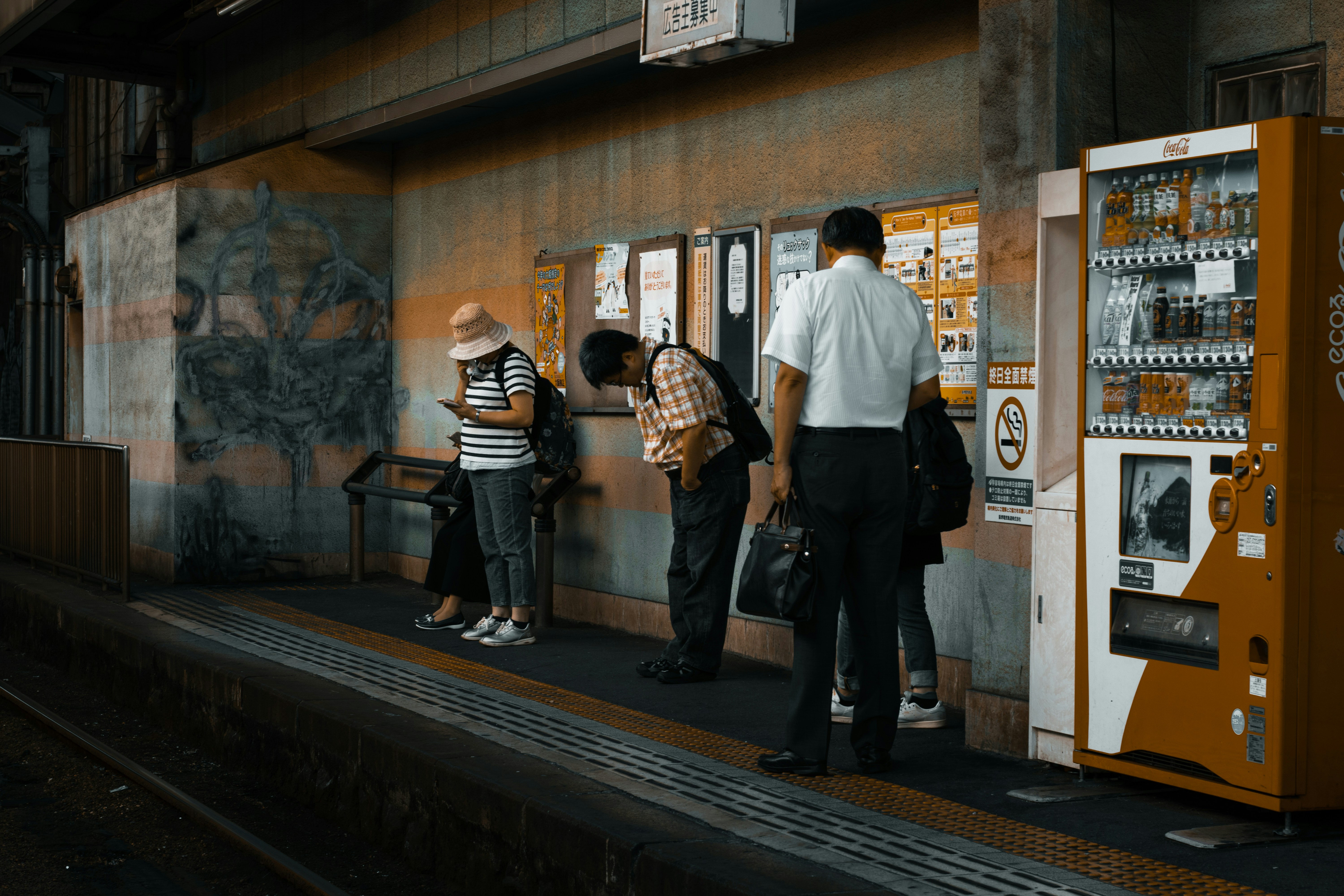 Traveler struggling with multiple large shopping bags at a Japanese train station