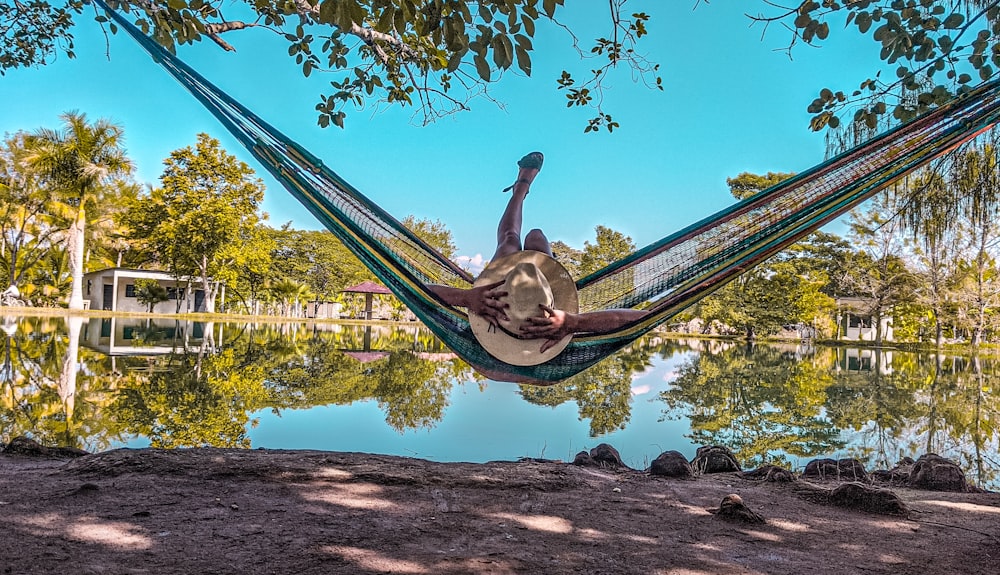 person lying on green hammock