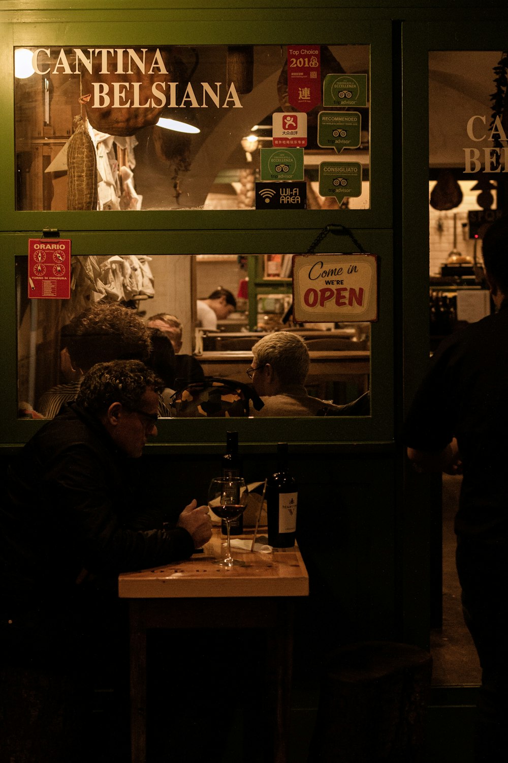 person on black coat sitting beside table