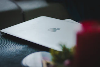 A high-end laptop open on a wooden desk with soft natural light