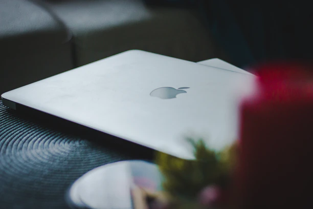 A high-end laptop open on a wooden desk with soft natural light