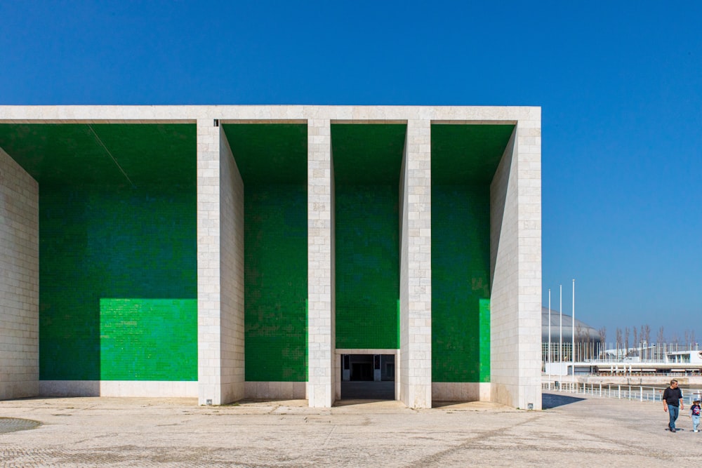 pessoas andando perto de um edifício branco durante o dia