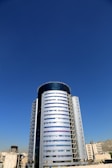 Exterior view of Bihar Trade Tower showcasing its towering glass facade against a clear sky.