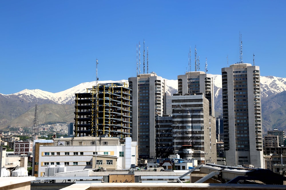 city with high-rise buildings viewing mountain under blue sky