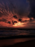 A dramatic sunset over the iconic Brazilian coastline with waves crashing gently