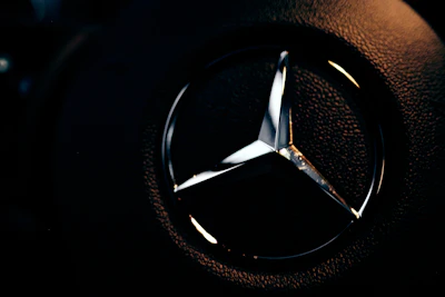 Close-up of a gold SSH monogram logo glowing softly against a deep navy background.