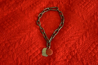 Close-up of handcrafted pet tags with unique designs on a soft fabric background.