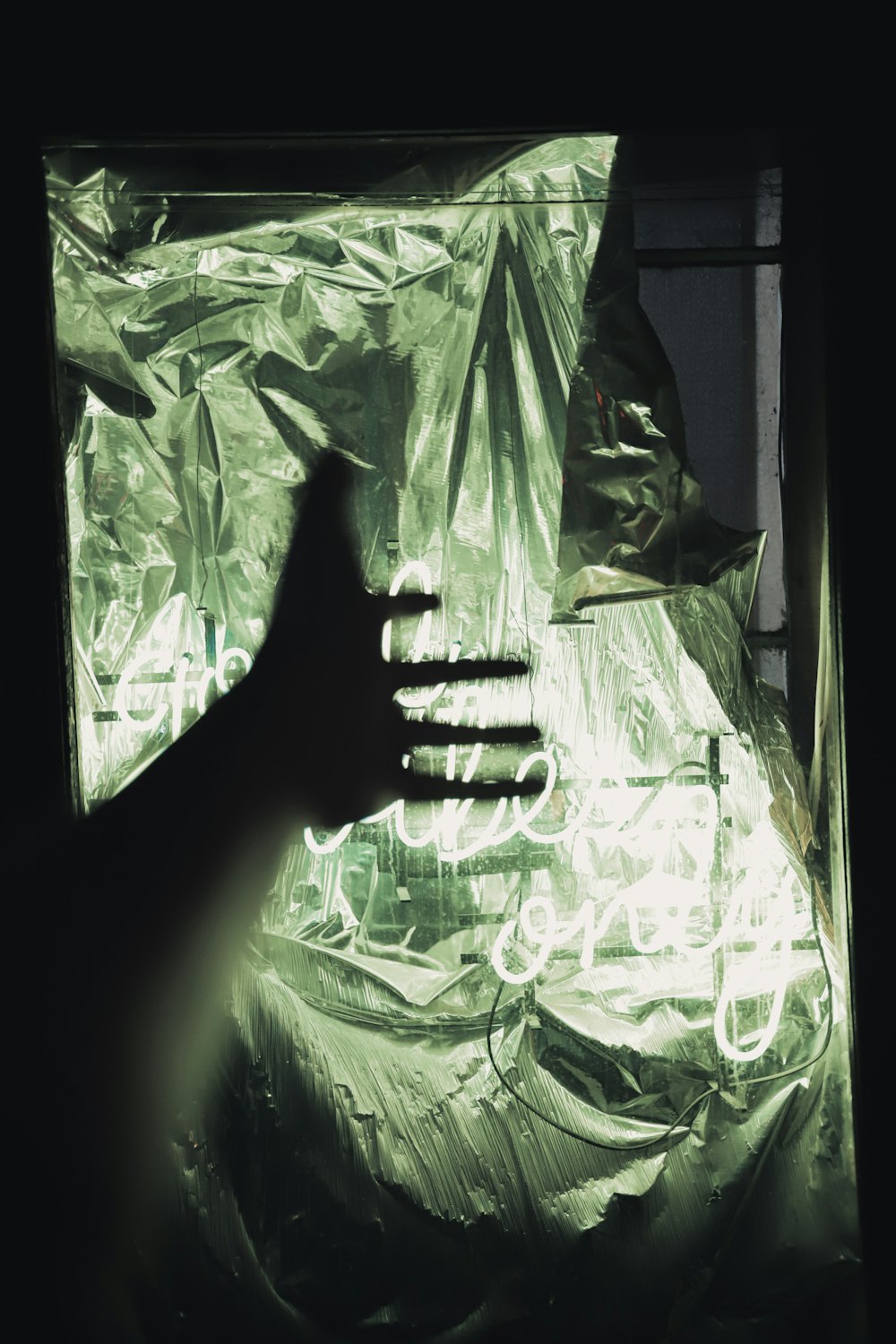 a person's hand reaching out of a plastic bag