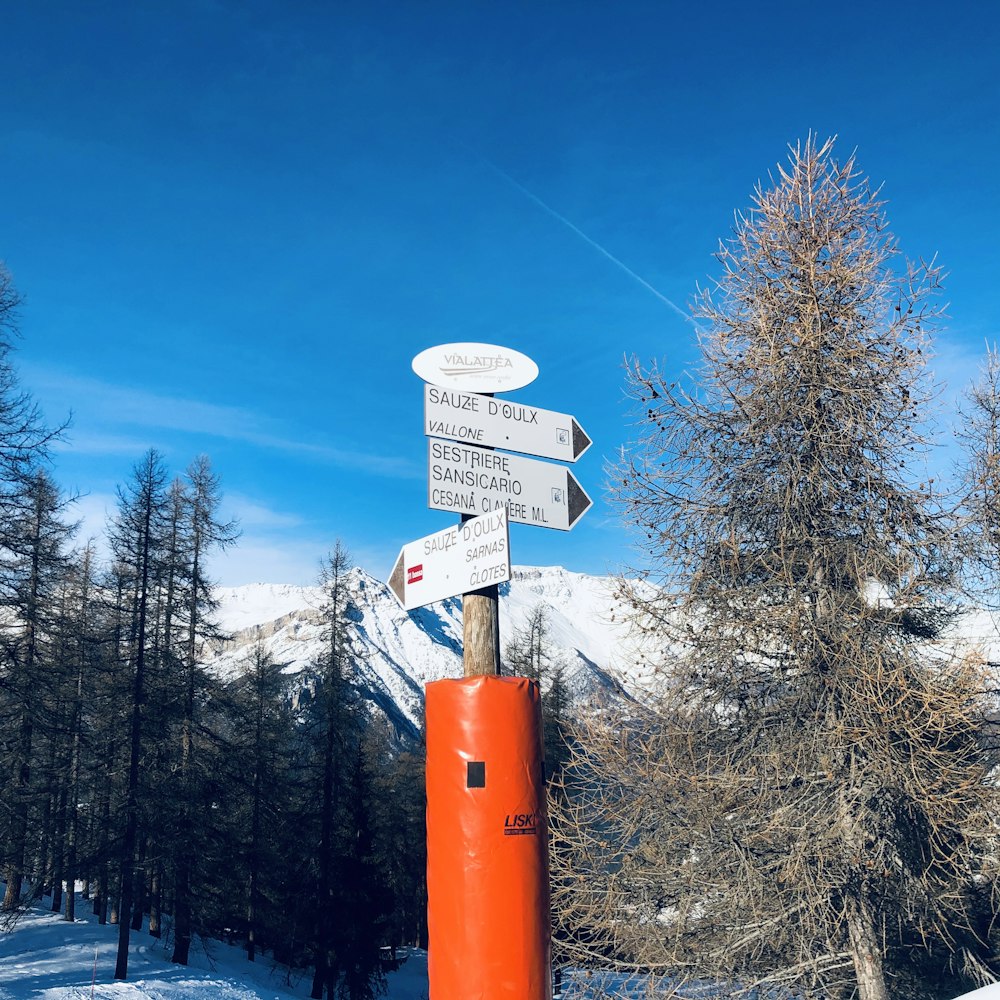 white and orange road signage under a calm blue sky