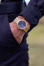 round gold-colored analog watch with link bracelet