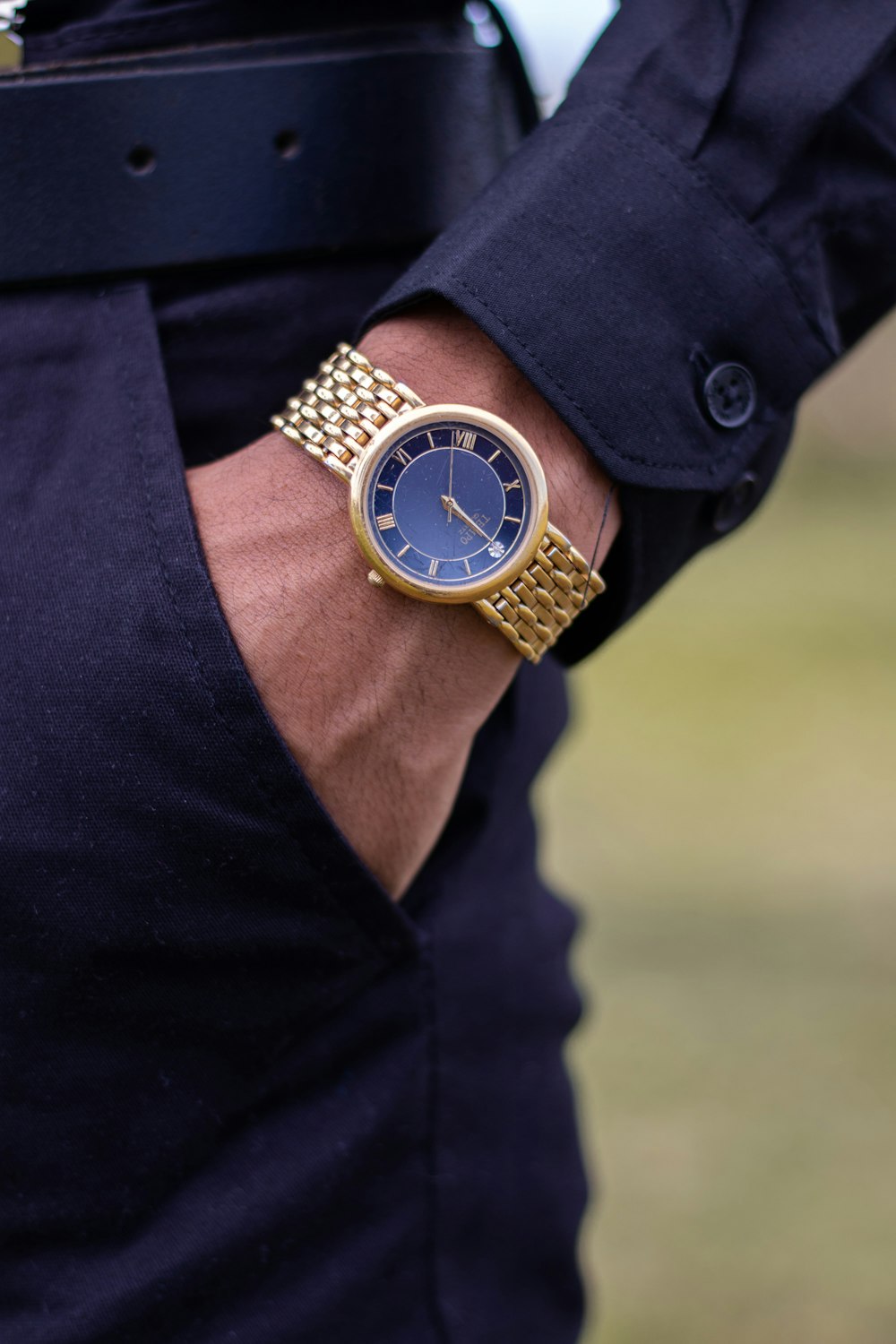 round gold-colored analog watch with link bracelet