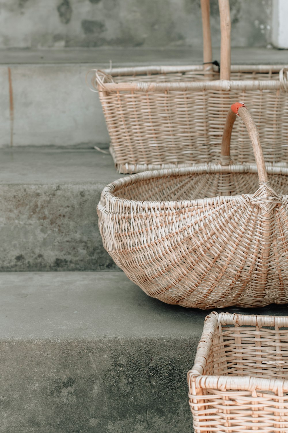 three brown wicker baskets on stairs