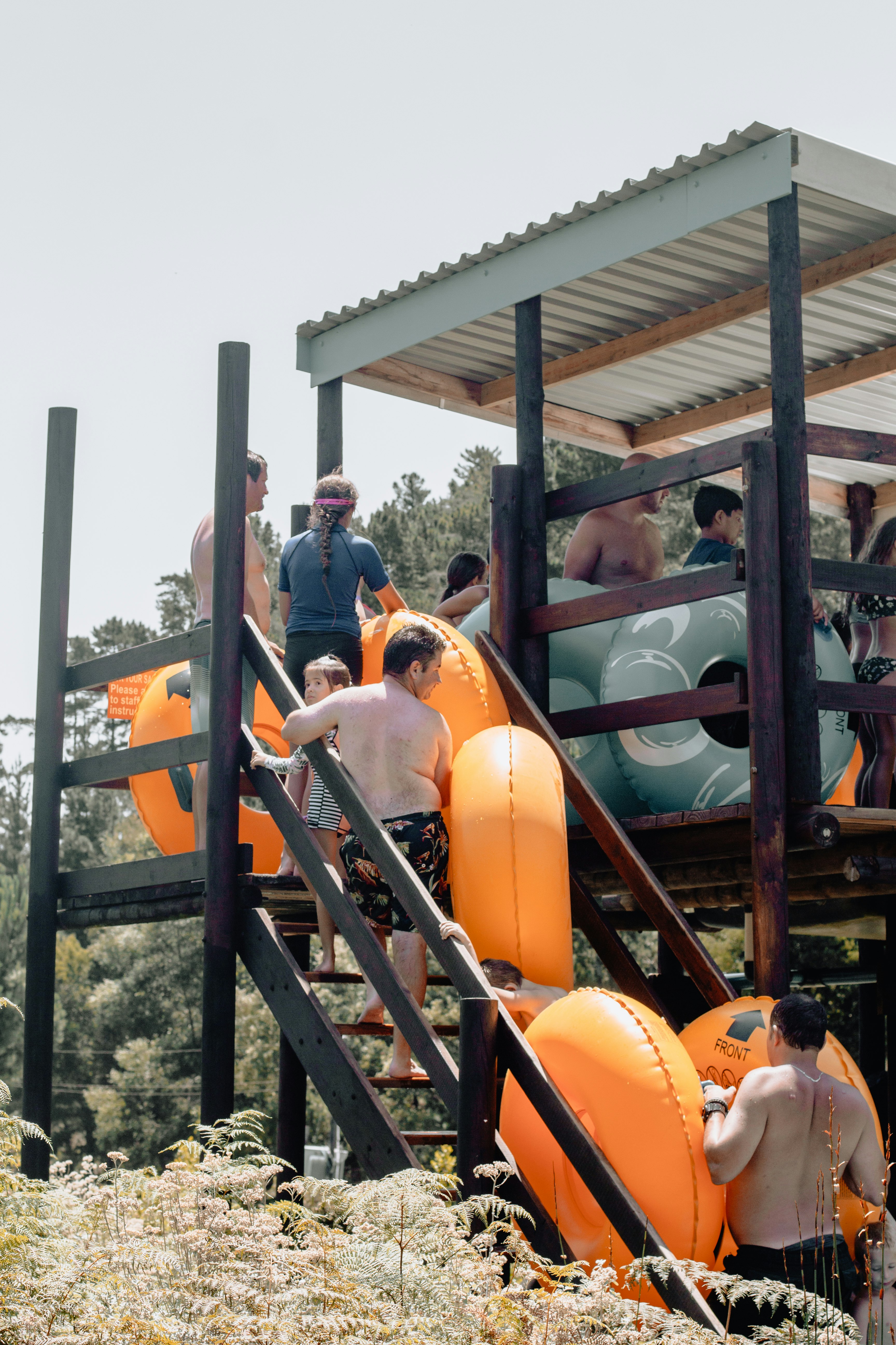 people with ring floats on pool slide