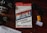 A book titled 'Influence: The Psychology of Persuasion' by Robert B. Cialdini is under a pair of sunglasses on a reddish-brown wooden surface. A camera with visible lens details is placed on the left. There is a roll of Kodak Gold 200 film and a small white container nearby.
