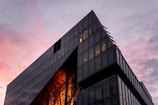 A sleek glass commercial building at sunset showcasing modern architecture.