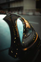 A detailed shot of a car’s headlight reflecting the city lights at night.