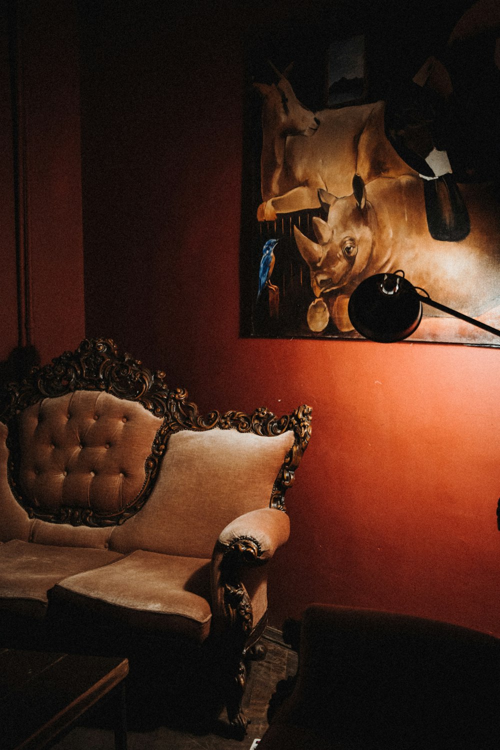 a living room with a chair and a painting on the wall