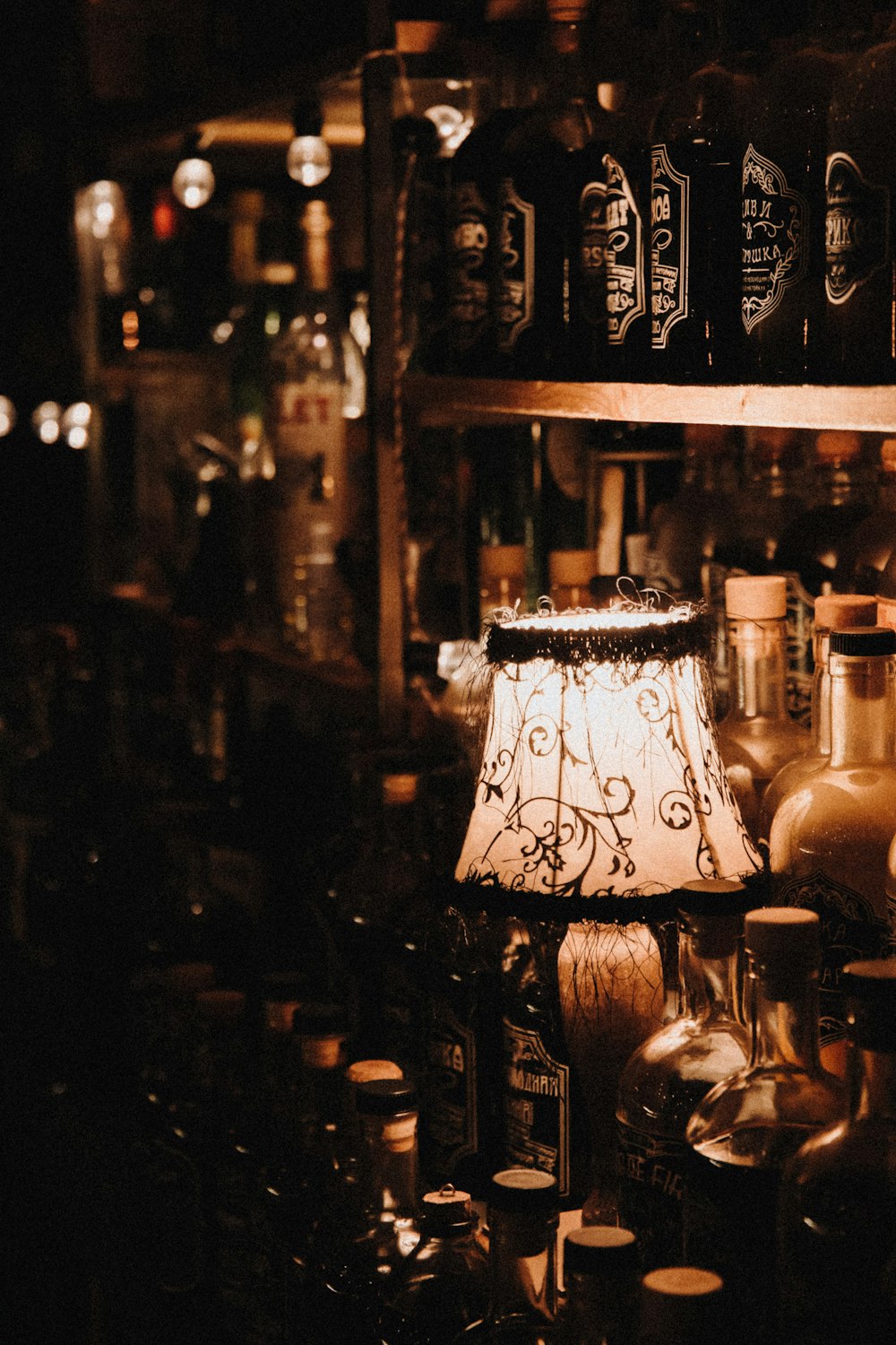 turned-on lap near shelf of wine bottles