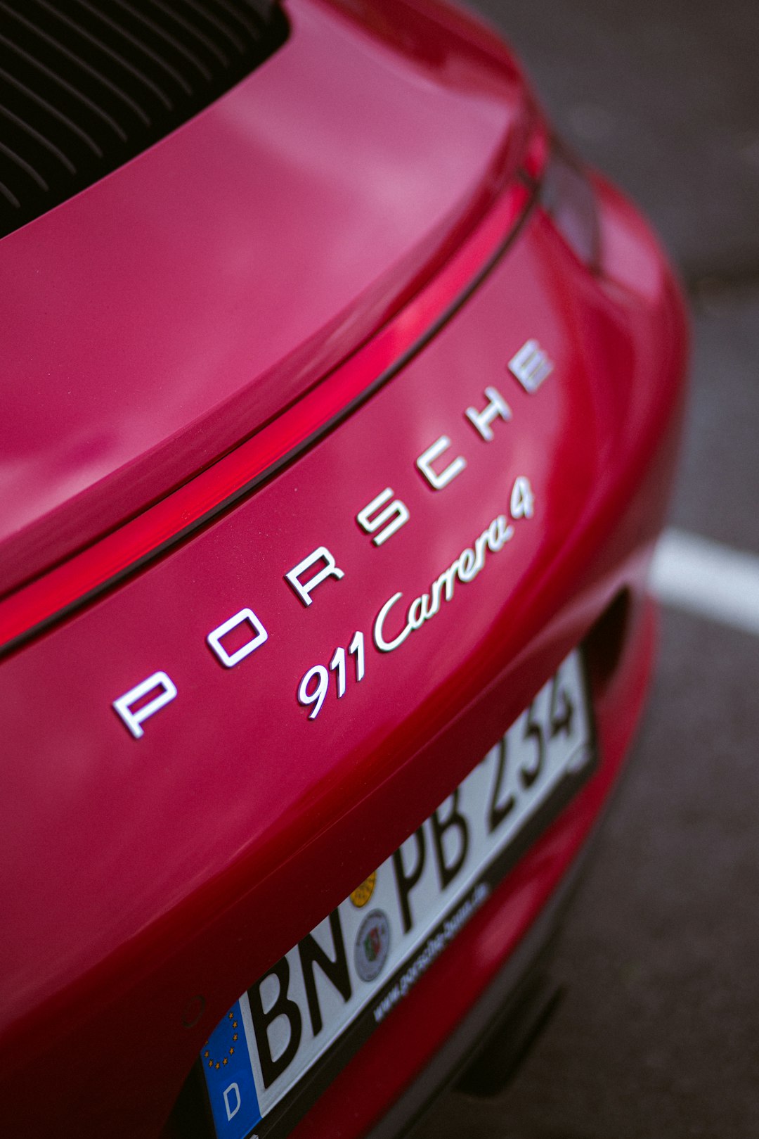 shallow focus photo of red Porsche 911 Carrera 4