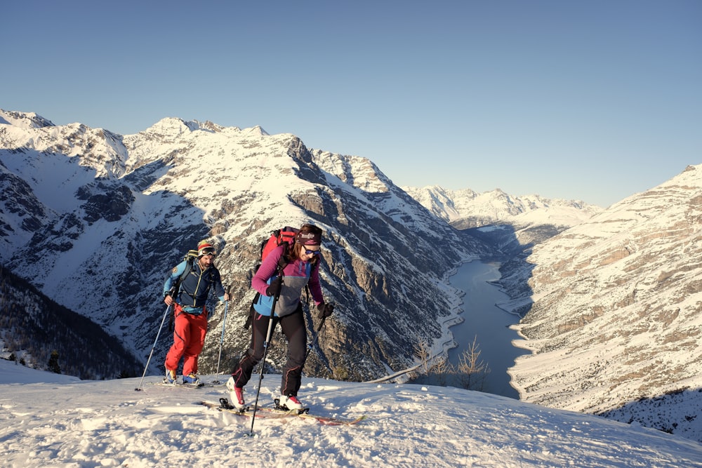man and woman walking trekking on snow
