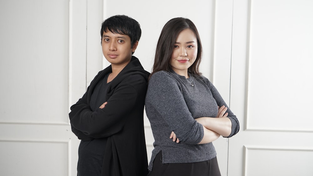 two women standing near white wall