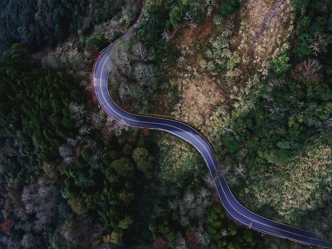 Aerial view of a winding mountain road through forest in Alishan Township, Chiayi County, Taiwan